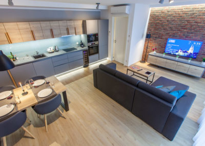 View at living room, dining table and kitchen of 1-bedroom apartment